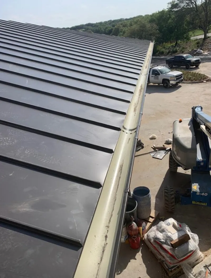 Standing seam panel and gutter detail on a metal roofing jobsite in Robstown
